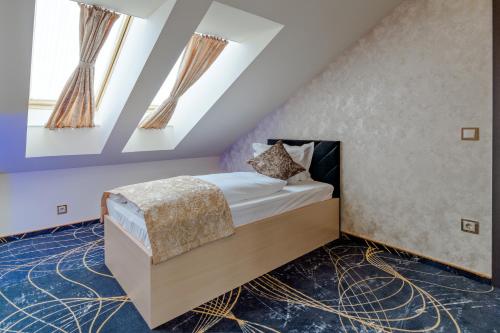 a bedroom with a bed in a attic at Diamond Panzió in Hajdúszoboszló