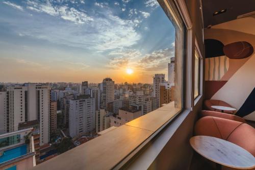 a balcony with a view of the city at sunset at Canopy By Hilton Sao Paulo Jardins in São Paulo