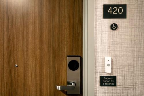 a door in a bathroom with a sign on the wall at Hyatt Place Fairbanks in Fairbanks