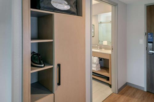 a door to a bathroom with a sink and a mirror at Hyatt Place Fairbanks in Fairbanks