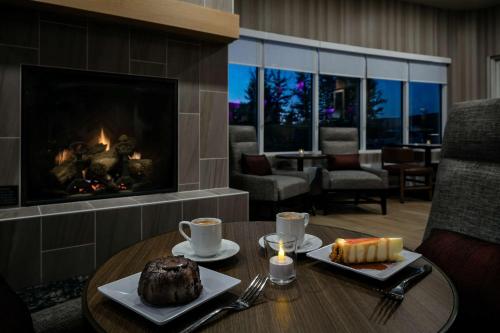 a room with a table with a cake and a fireplace at Hyatt Place Fairbanks in Fairbanks