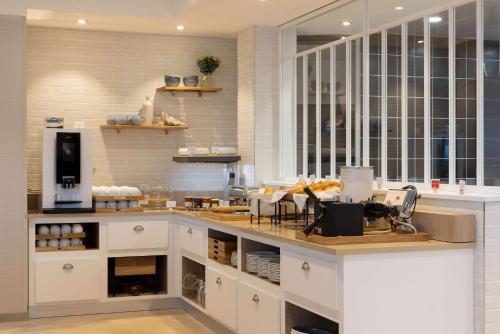 cocina con armarios blancos y encimera en Hilton Garden Inn Le Havre Centre, en Le Havre