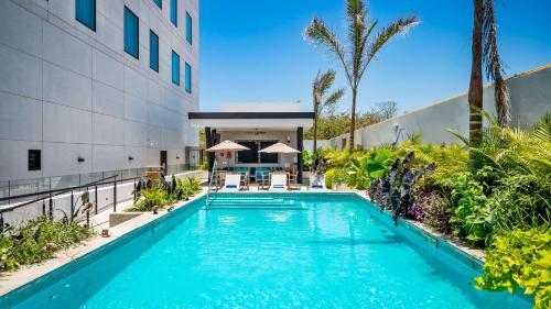 a swimming pool in front of a building at Hampton Inn By Hilton Nuevo Vallarta in Nuevo Vallarta 