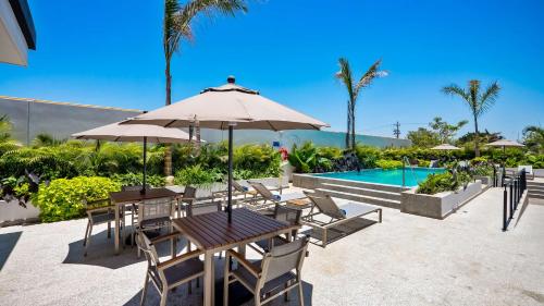 a table and chairs with an umbrella next to a pool at Hampton Inn By Hilton Nuevo Vallarta in Nuevo Vallarta 