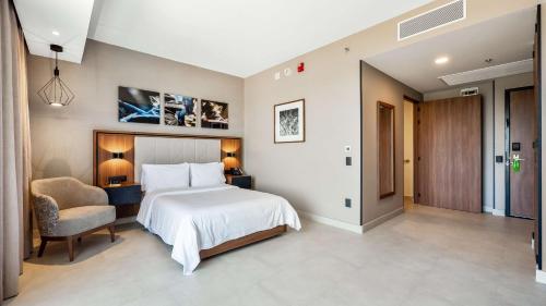 a bedroom with a large bed and a chair at Hampton Inn By Hilton Nuevo Vallarta in Nuevo Vallarta 