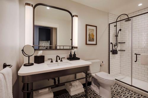 a bathroom with a sink and a toilet and a mirror at Canopy By Hilton Boston Downtown in Boston