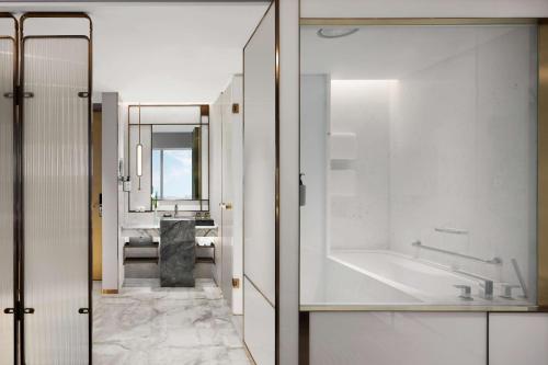a bathroom with a tub and a sink at Conrad Shanghai in Shanghai