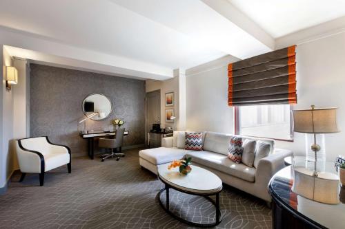 a living room with a couch and a table at Colcord Hotel Oklahoma City, Curio Collection by Hilton in Oklahoma City