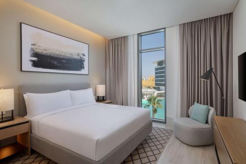 um quarto de hotel com uma cama e uma grande janela em Doubletree By Hilton Abu Dhabi Yas Island Residences em Abu Dhabi