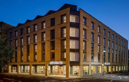 a large brick building on the corner of a street at Hampton By Hilton Bath City in Bath