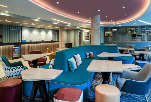 a lobby with a blue couch and tables at Hampton By Hilton Bath City in Bath