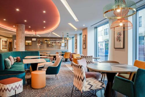a hotel lobby with tables and chairs and tablesktop at Hampton By Hilton Bath City in Bath