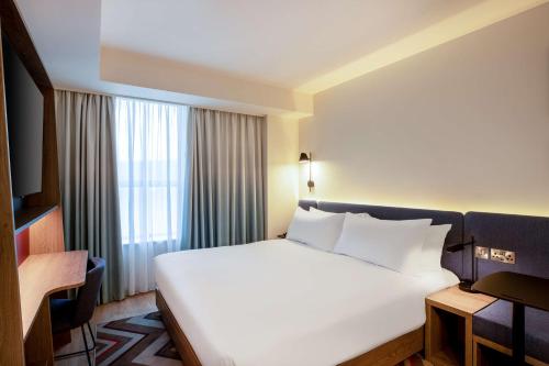 a bedroom with a large white bed and a window at Hampton By Hilton Bath City in Bath
