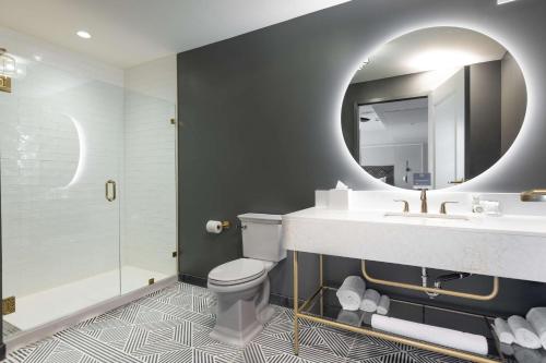 a bathroom with a sink and a toilet and a mirror at The Kelly Birmingham, Tapestry Collection By Hilton in Birmingham