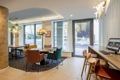 a dining room with tables and chairs and windows at Hampton By Hilton Bath City in Bath