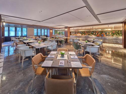 - un restaurant avec des tables et des chaises dans une salle dans l'établissement Doubletree By Hilton Yancheng Dayangwan, à Yancheng