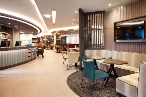 a restaurant with tables and chairs and a bar at Hampton By Hilton Regensburg in Regensburg