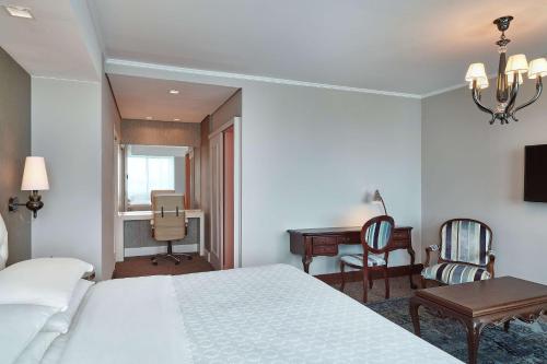 a bedroom with a bed and a desk and a chair at Hilton Porto Alegre, Brazil in Porto Alegre