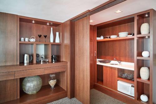 a kitchen with wooden cabinets and shelves with vases at Hilton Porto Alegre, Brazil in Porto Alegre