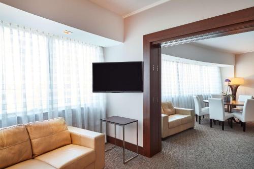 a living room with a couch and a television at Hilton Porto Alegre, Brazil in Porto Alegre