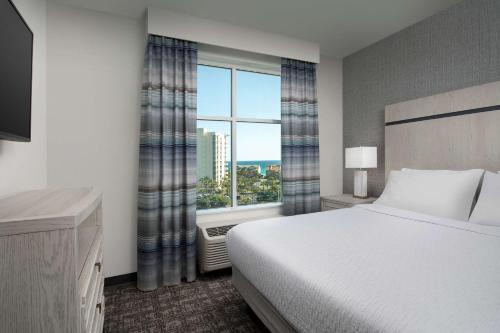 a bedroom with a bed and a large window at Homewood Suites By Hilton Destin in Destin