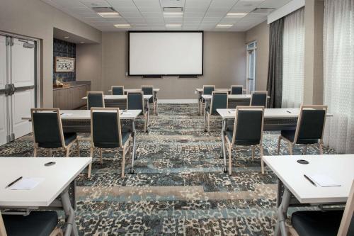 a conference room with tables and chairs and a screen at Homewood Suites By Hilton Destin in Destin