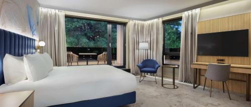 a hotel room with a bed and a television at Doubletree By Hilton Plovdiv Center in Plovdiv