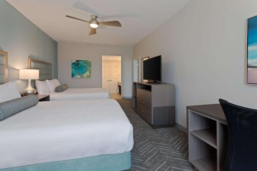 a hotel room with two beds and a flat screen tv at Homewood Suites By Hilton Panama City Beach, Fl in Panama City Beach