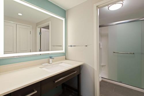 a bathroom with a sink and a mirror and a shower at Homewood Suites By Hilton Panama City Beach, Fl in Panama City Beach