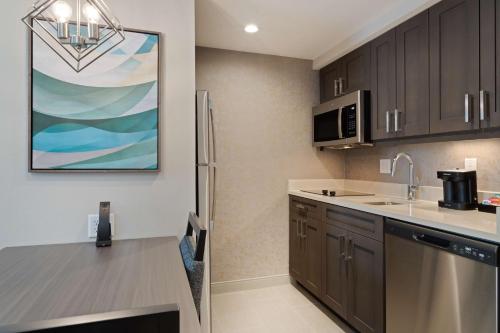 a kitchen with a sink and a refrigerator at Homewood Suites By Hilton Panama City Beach, Fl in Panama City Beach