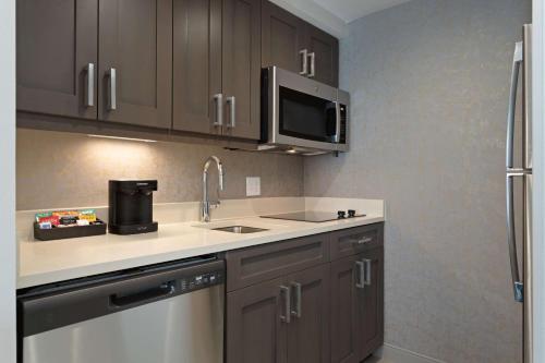 a kitchen with a sink and a microwave at Homewood Suites By Hilton Panama City Beach, Fl in Panama City Beach