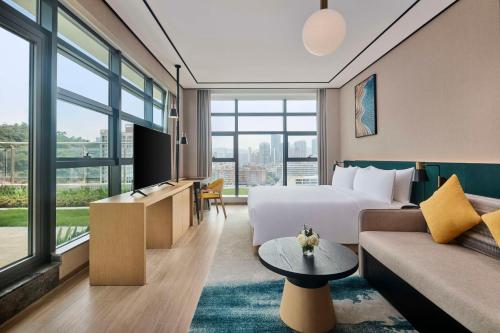 Habitación de hotel con cama y sofá en Hilton Garden Inn Zhuhai Jinan University, en Zhuhai