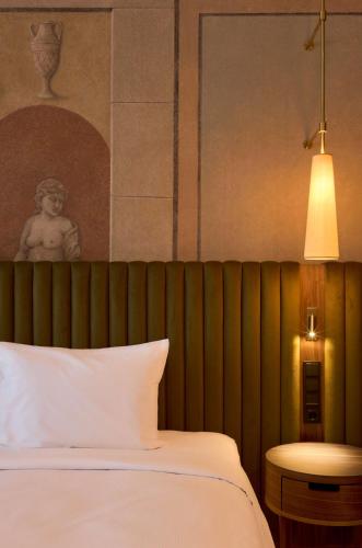 a bedroom with a bed and a table and a lamp at Hotel Saski Krakow Curio Collection by Hilton in Kraków