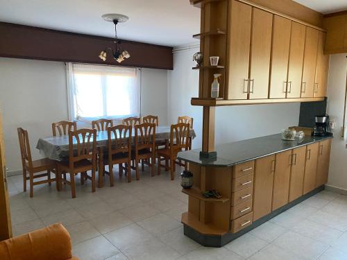 cocina y comedor con mesa y sillas en Casa Portomeiro, en San Román
