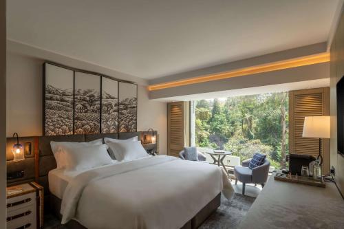 a bedroom with a large bed and a large window at Kwetu Nairobi, Curio Collection By Hilton in Nairobi