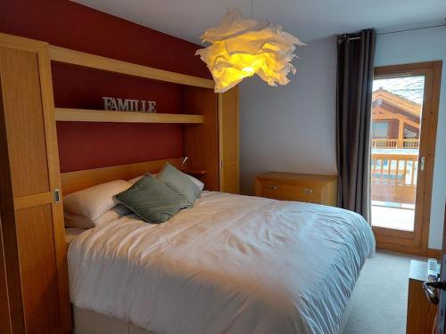 a bedroom with a large bed and a chandelier at La Reine des Prés in Sainte-Foy-Tarentaise