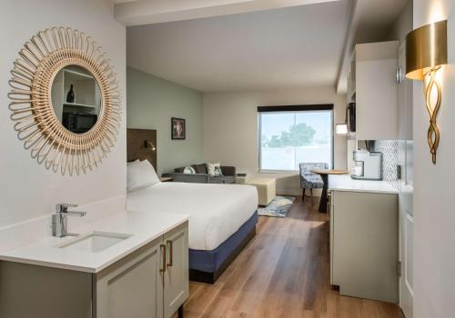 a hotel room with a bed and a sink and a mirror at Coast Rehoboth Beach, Tapestry Collection By Hilton in Rehoboth Beach