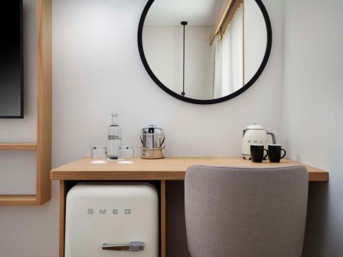 - une table avec un miroir et une chaise dans la chambre dans l'établissement Hilton Garden Inn Evora, à Évora