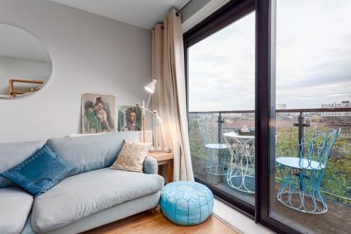 a living room with a couch and a large window at Bright and Stylish Kennington Gem in London