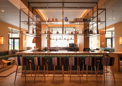 a bar in a restaurant with chairs around it at Hilton Garden Inn Evora in Évora