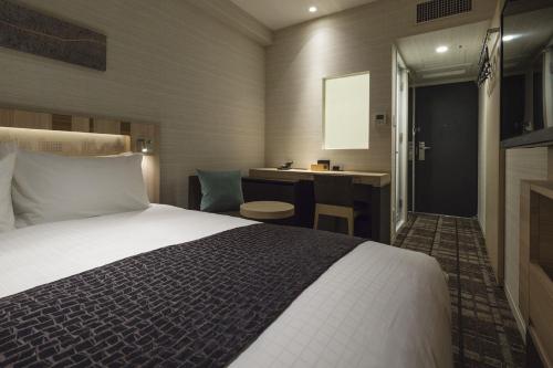 a hotel room with a bed and a desk at Hotel Sunroute Ginza in Tokyo
