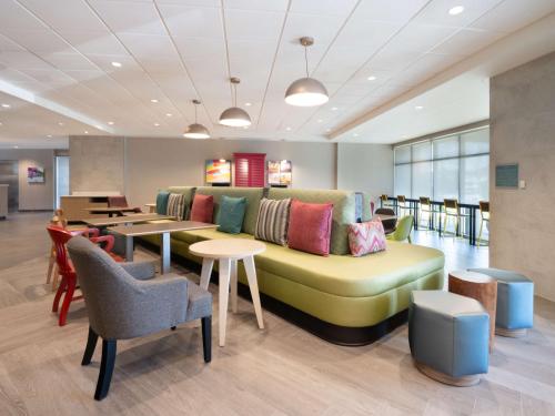 a living room with a couch and tables and chairs at Home2 Suites By Hilton Santa Rosa Beach in Santa Rosa Beach
