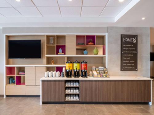 a coffee shop with a counter with a flat screen tv at Home2 Suites By Hilton Santa Rosa Beach in Santa Rosa Beach