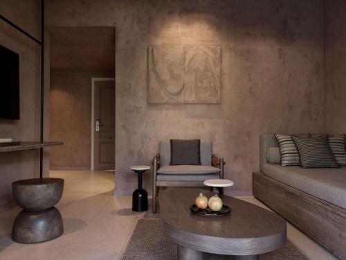a living room with a bed and a table and a chair at Lindian Village All Inclusive Resort Rhodes,Curio Collection in Kiotari