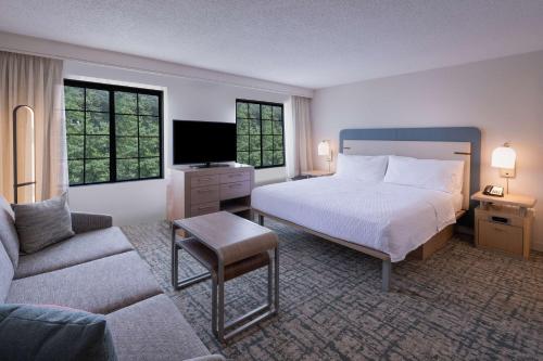 アトランタにあるHomewood Suites by Hilton Atlanta Buckhead Pharr Roadのベッドとソファ付きのホテルルーム