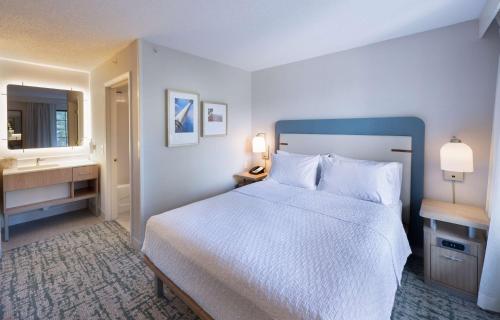 a bedroom with a large white bed and a bathroom at Homewood Suites by Hilton Atlanta Buckhead Pharr Road in Atlanta