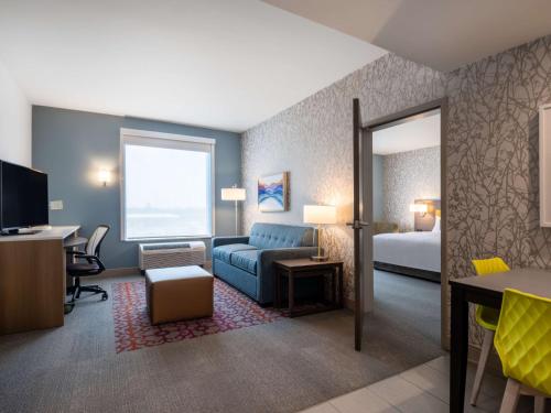 a hotel room with a couch and a bed at Home2 Suites By Hilton Santa Rosa Beach in Santa Rosa Beach