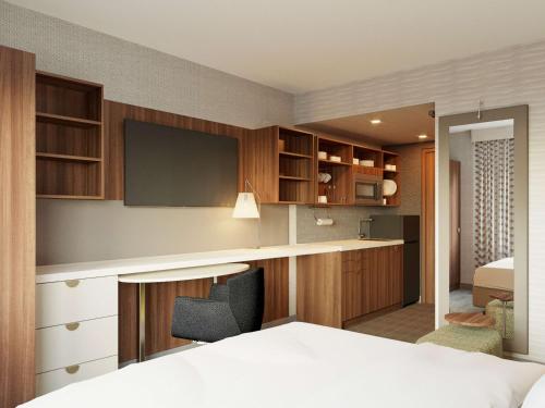 1 dormitorio con 1 cama y escritorio con TV en Home2 Suites By Hilton New York Times Square, en Nueva York