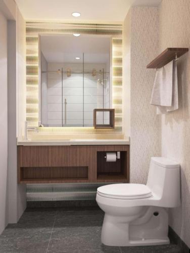 łazienka z toaletą i dużym lustrem w obiekcie Home2 Suites By Hilton New York Times Square w Nowym Jorku