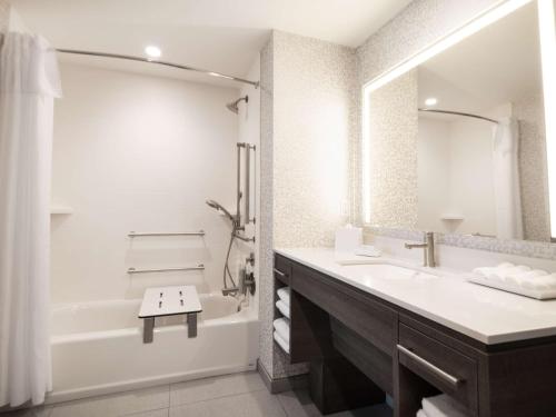 a white bathroom with a tub and a sink and a shower at Home2 Suites By Hilton Santa Rosa Beach in Santa Rosa Beach